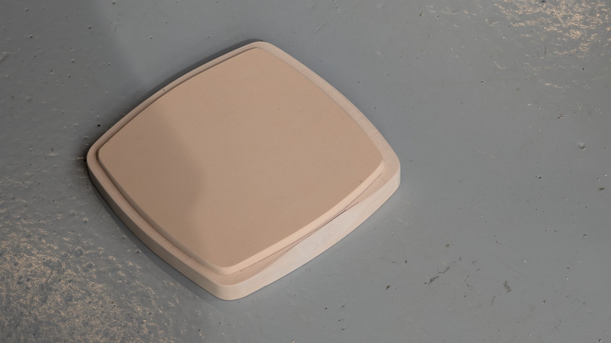 Blush foam study model of the scale, rounded-square with a thick pillowed edge, shot from above