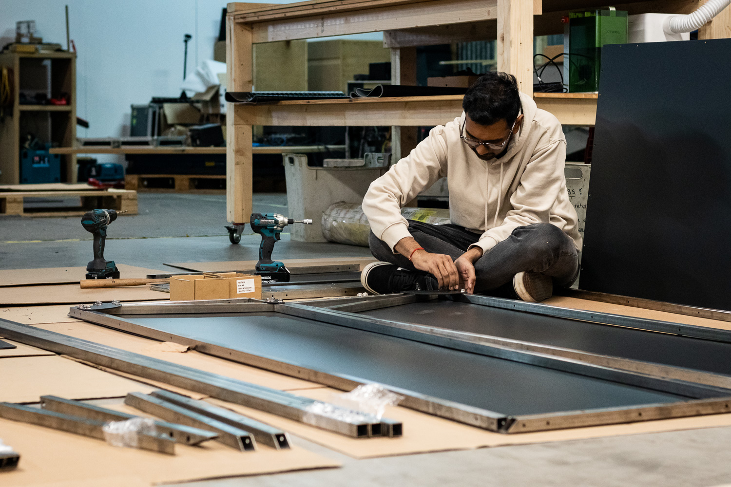 Man assembling furniture with power tools in a workshop