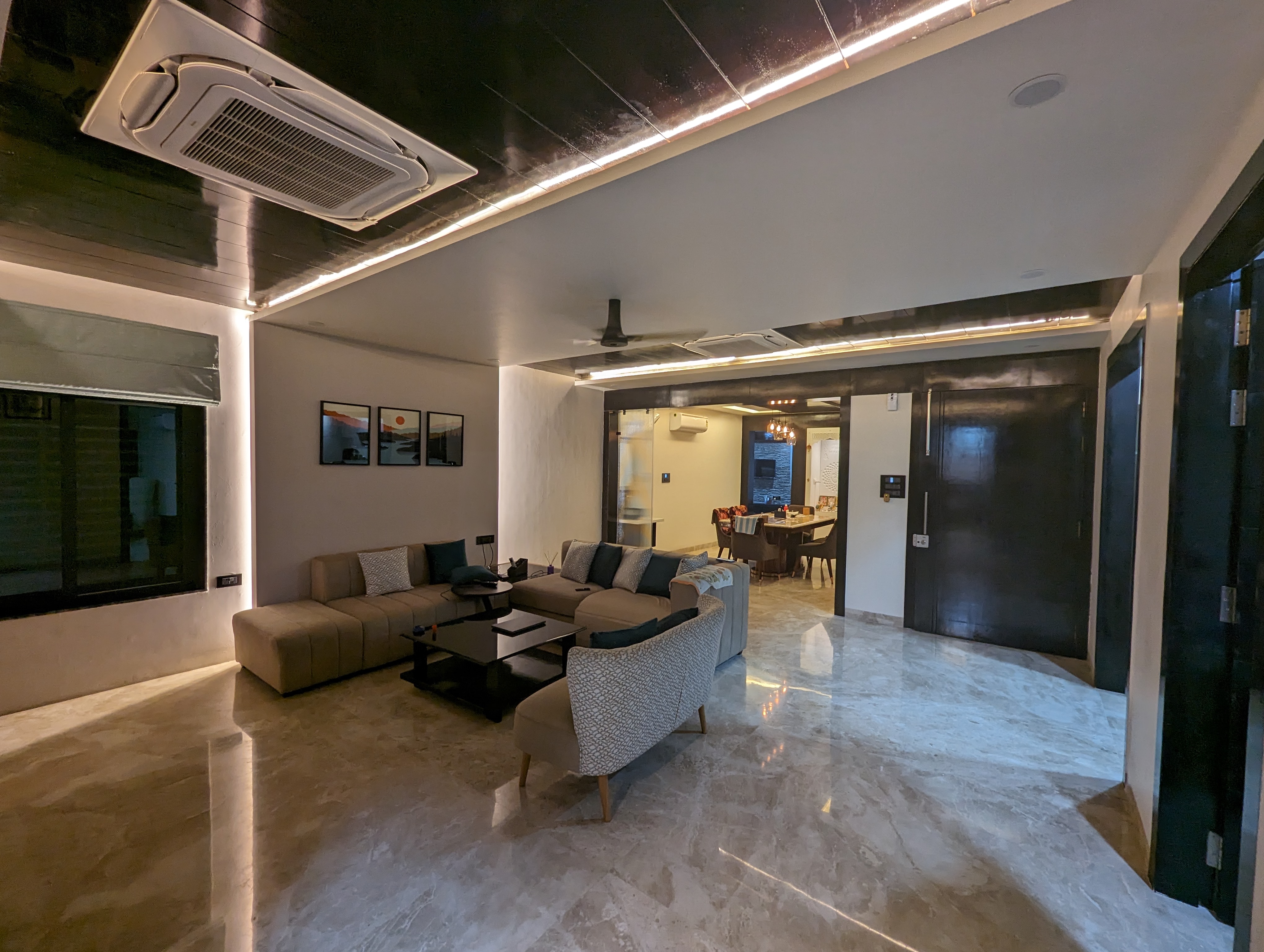 Living room as built - sectional sofa, marble floor and dining beyond the dark-panelled doorway